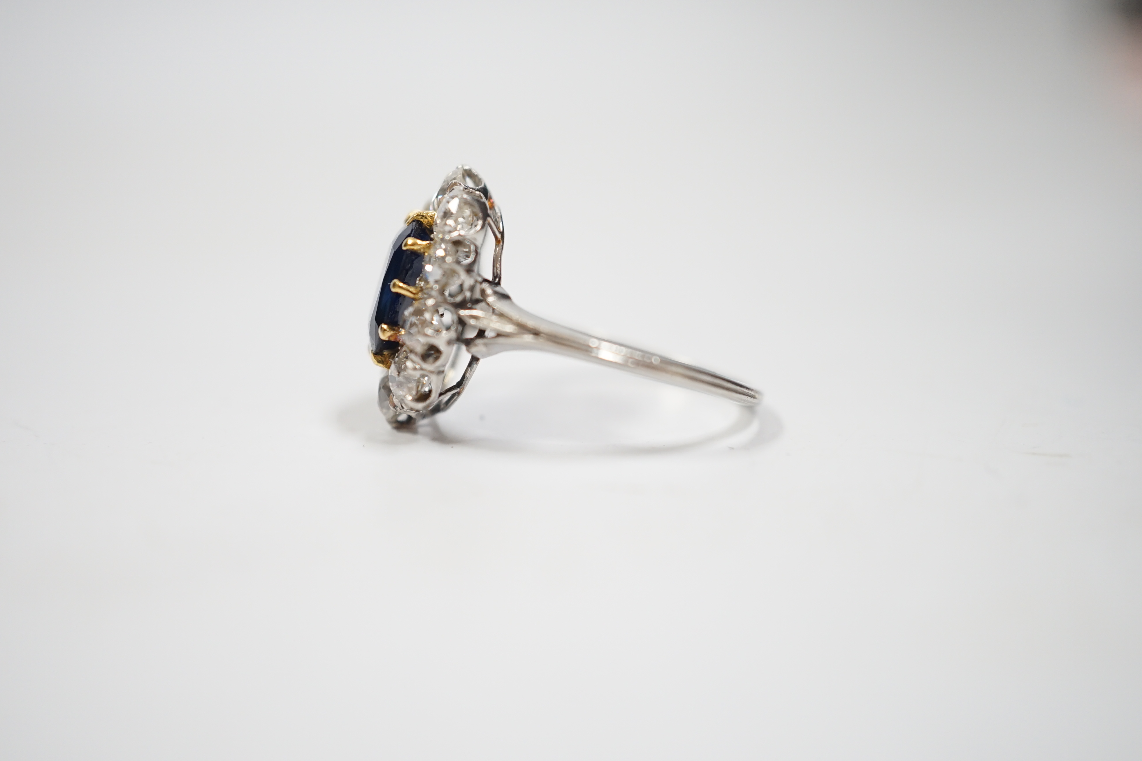 A white metal, synthetic sapphire and diamond set oval cluster ring, size M, gross weight 3.8 grams.